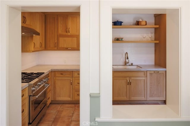 kitchen with backsplash, high end stove, sink, and light tile patterned floors