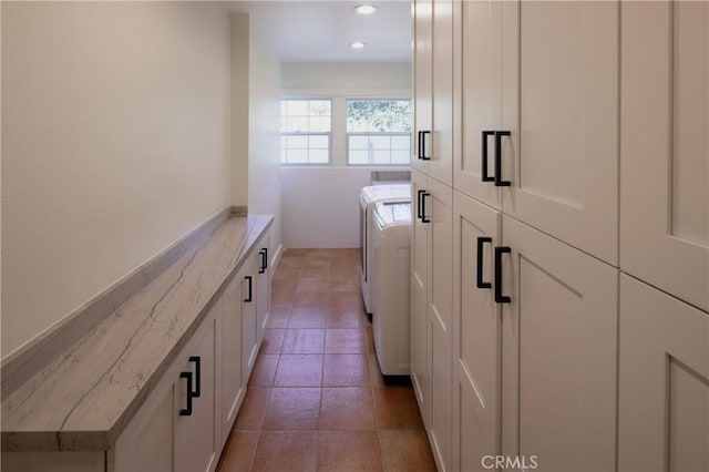 laundry room featuring washing machine and clothes dryer and cabinets