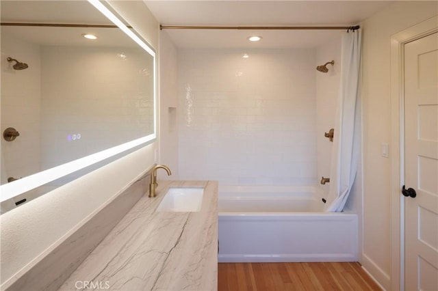 bathroom featuring hardwood / wood-style floors, shower / bath combo, and vanity