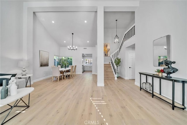 foyer entrance with light hardwood / wood-style flooring and high vaulted ceiling