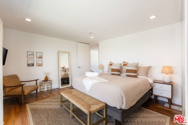 bedroom with dark hardwood / wood-style floors