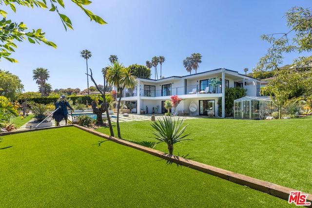 view of yard featuring a balcony and a swimming pool