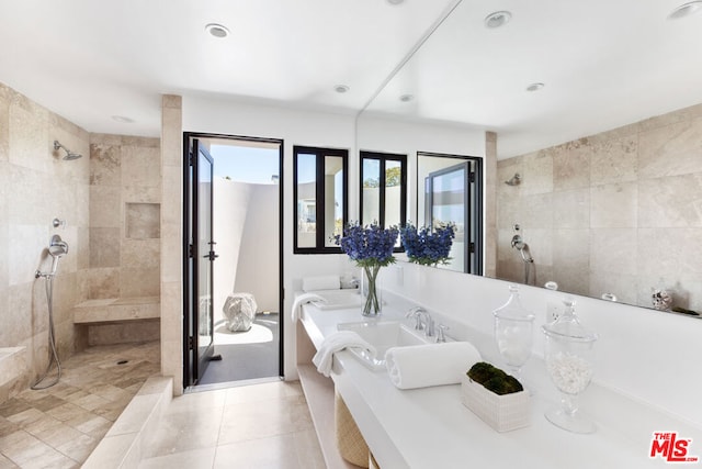 bathroom with tiled shower, tile patterned floors, and sink