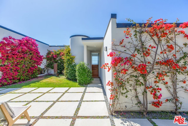 property entrance featuring a lawn