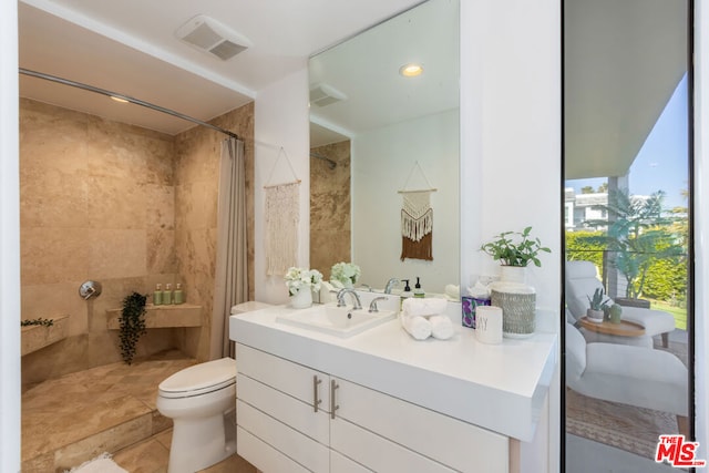 bathroom with a shower with curtain, tile patterned flooring, vanity, and toilet