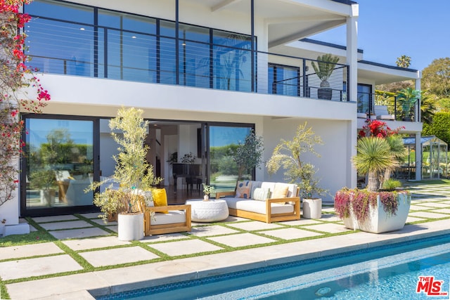 rear view of property with a patio area, a balcony, and an outdoor hangout area