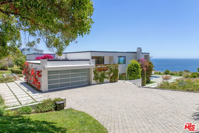 contemporary home with a water view and a garage