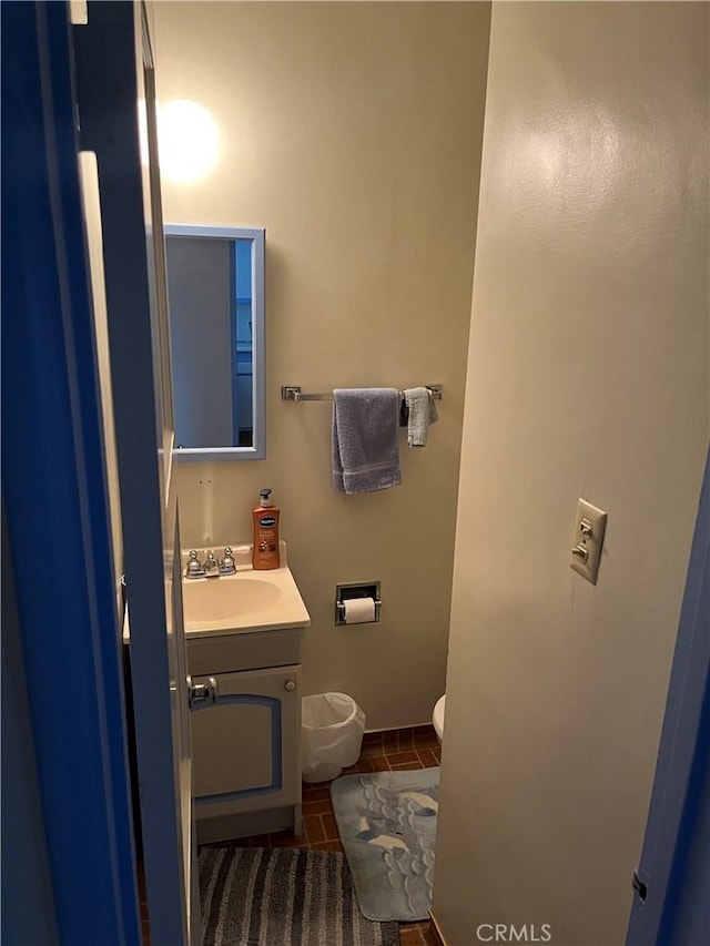 bathroom featuring tile patterned flooring, vanity, and toilet