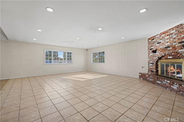 unfurnished living room with light tile patterned floors and a fireplace