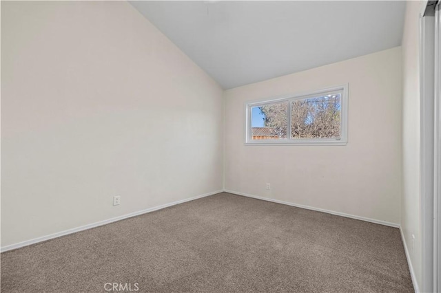 carpeted spare room with vaulted ceiling