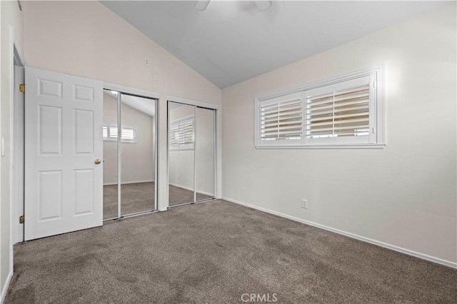 unfurnished bedroom with ceiling fan, vaulted ceiling, multiple closets, and carpet flooring