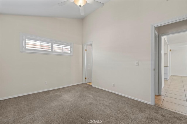 spare room with vaulted ceiling, light carpet, and ceiling fan