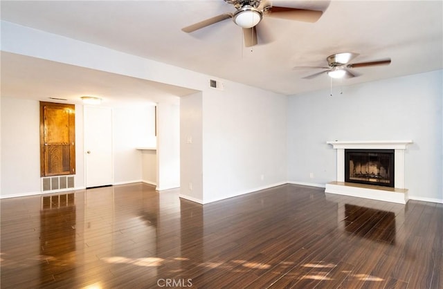 unfurnished living room with dark hardwood / wood-style flooring and ceiling fan