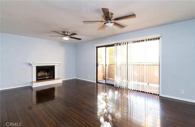 unfurnished living room with ceiling fan and dark wood-type flooring