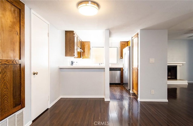 kitchen with appliances with stainless steel finishes and dark hardwood / wood-style flooring