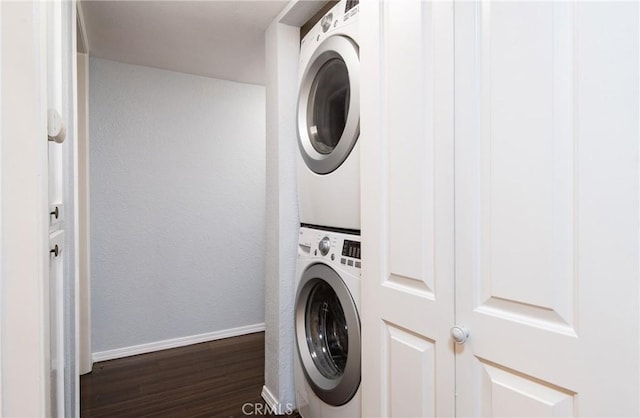 laundry room featuring dark hardwood / wood-style floors and stacked washer and clothes dryer