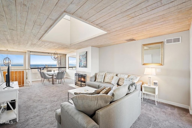 living room with carpet, a water view, and wood ceiling