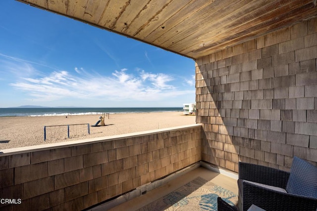 balcony featuring a water view and a beach view