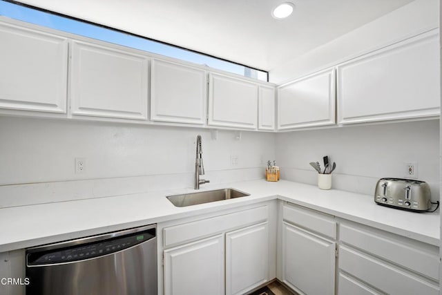 kitchen featuring white cabinets, stainless steel dishwasher, and sink