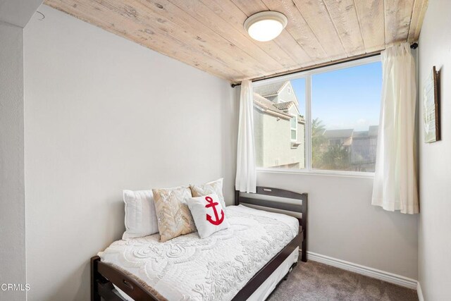 carpeted bedroom with wooden ceiling and multiple windows