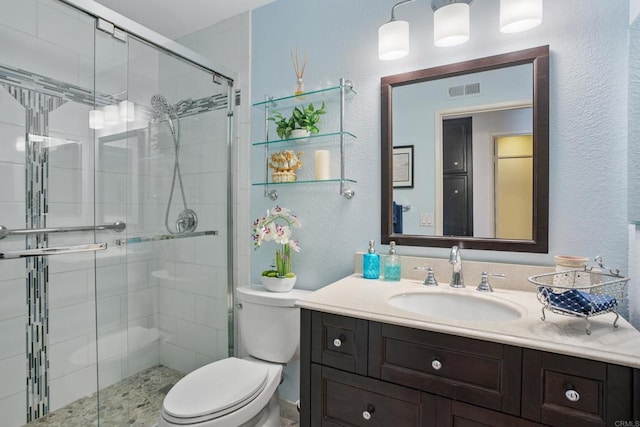 bathroom with vanity, toilet, and a shower with shower door