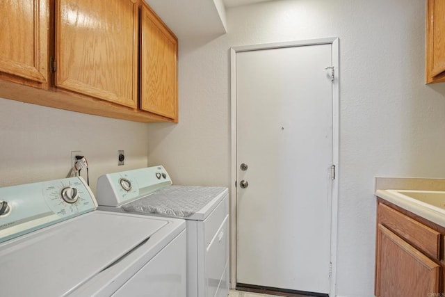 laundry area with washer and clothes dryer and cabinets