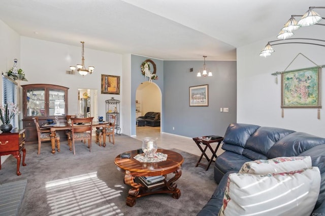 living room featuring carpet flooring, lofted ceiling, and a chandelier