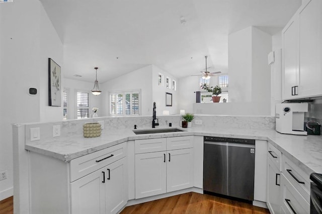 kitchen with stainless steel dishwasher, white cabinets, kitchen peninsula, and sink