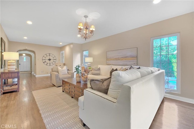 living room with light wood-type flooring and an inviting chandelier