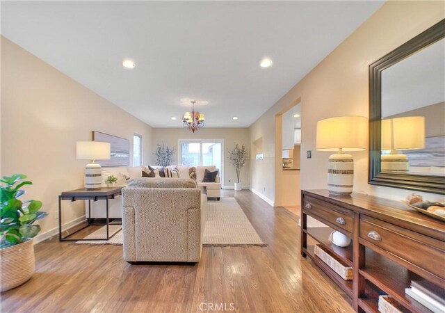 living room with hardwood / wood-style floors and an inviting chandelier