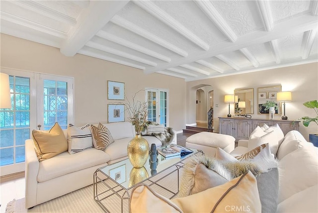 living room with beamed ceiling, light hardwood / wood-style floors, and french doors