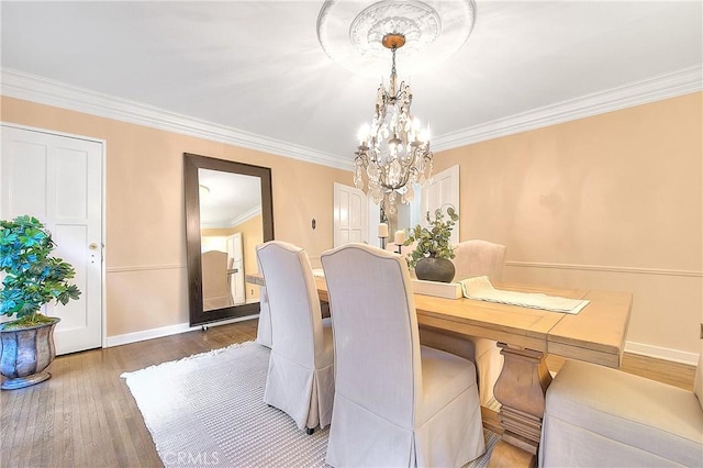 dining room featuring dark hardwood / wood-style floors, crown molding, and a notable chandelier