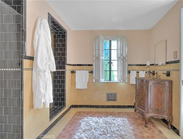 bathroom with tile patterned floors, vanity, and tile walls