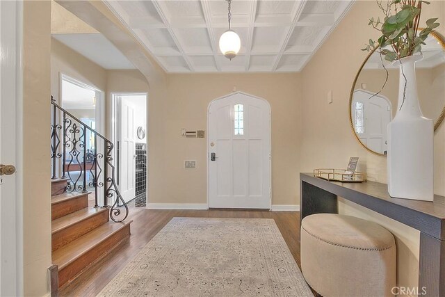 foyer entrance with beamed ceiling, wood-type flooring, and coffered ceiling