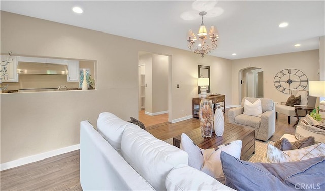 living room with a chandelier and light hardwood / wood-style floors