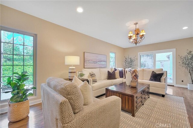 living room featuring a notable chandelier, plenty of natural light, and light hardwood / wood-style floors