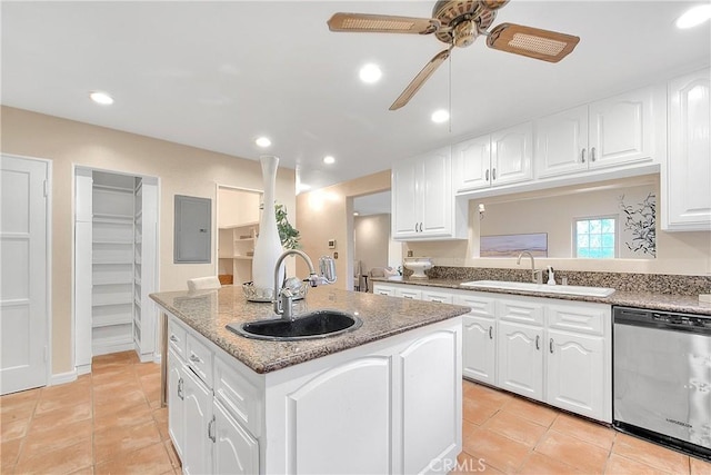 kitchen featuring white cabinets, sink, an island with sink, and stainless steel dishwasher