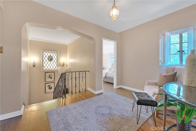 sitting room with wood-type flooring and ornamental molding