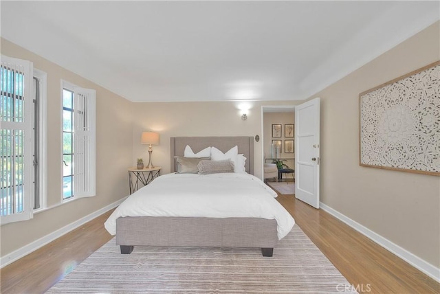 bedroom featuring light hardwood / wood-style floors and multiple windows