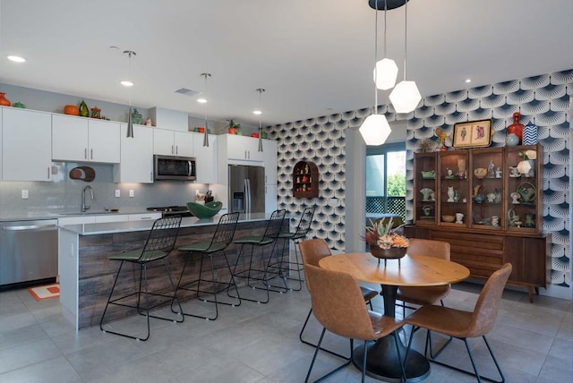 tiled dining room featuring sink