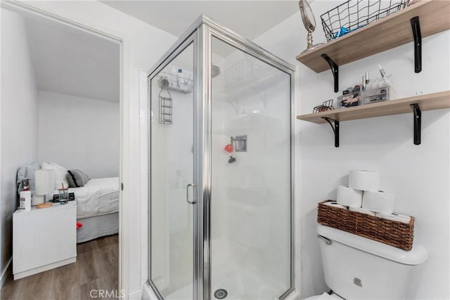 bathroom featuring wood-type flooring, an enclosed shower, and toilet