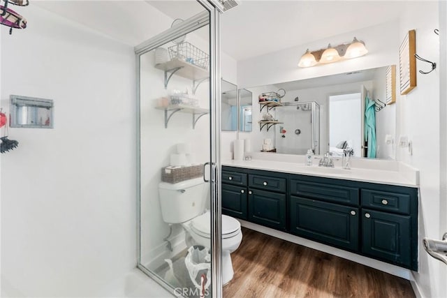 bathroom featuring hardwood / wood-style flooring, vanity, toilet, and an enclosed shower