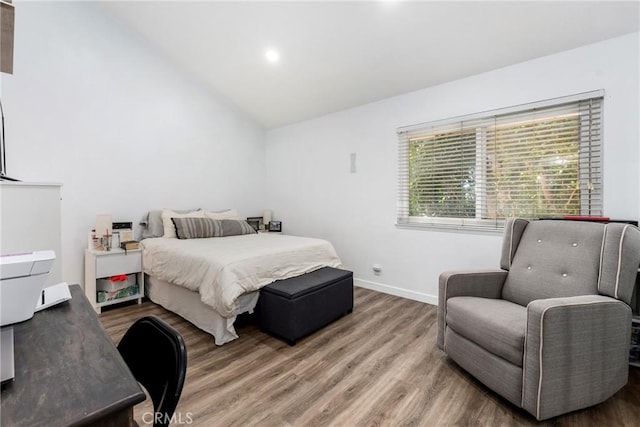 bedroom with hardwood / wood-style floors and lofted ceiling