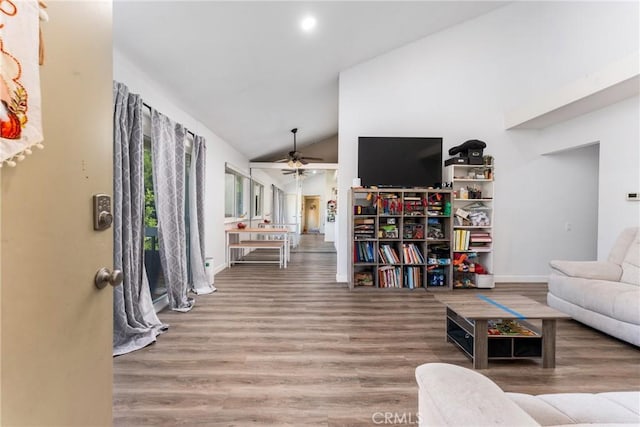 living room featuring ceiling fan, wood-type flooring, and vaulted ceiling