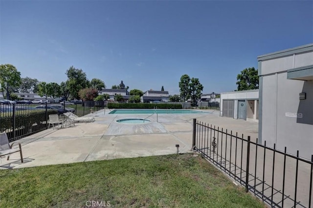 pool featuring a community hot tub, a patio area, and fence