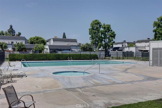 pool featuring a community hot tub, fence, and a patio