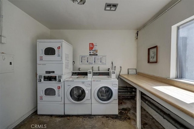 shared laundry area with stacked washer / dryer, a healthy amount of sunlight, visible vents, and washing machine and clothes dryer