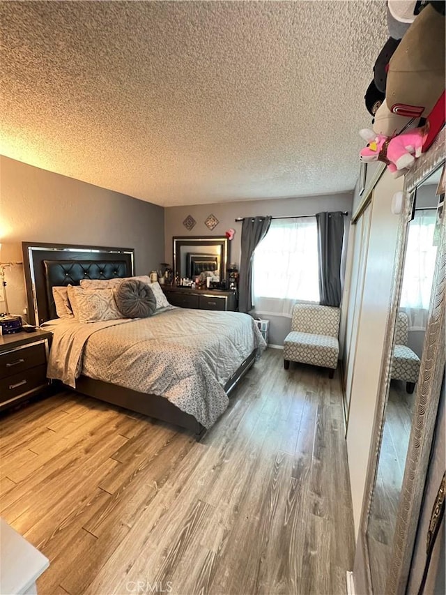 bedroom featuring a textured ceiling and wood finished floors