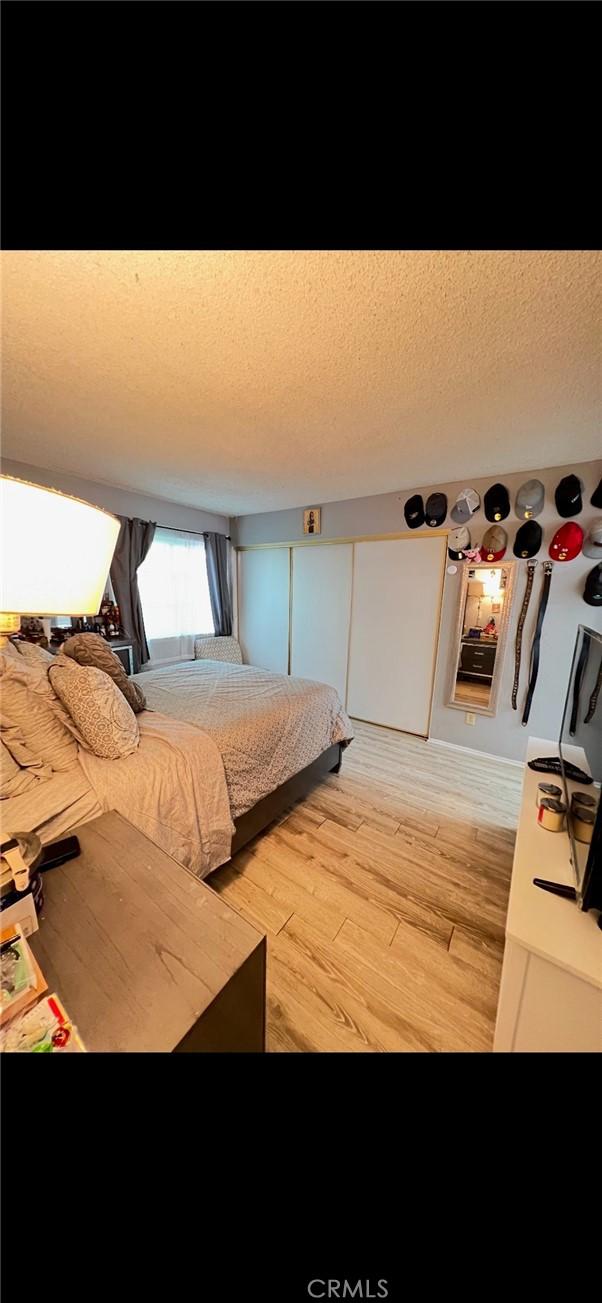 bedroom featuring a textured ceiling and light wood-type flooring