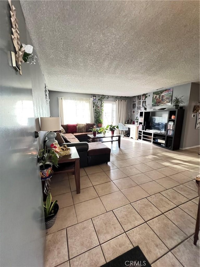 living area with tile patterned flooring, built in shelves, and a textured ceiling